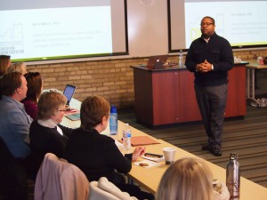 Milner standing in front of workshop participants