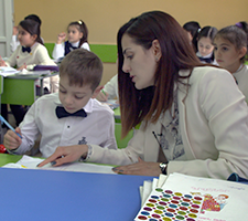 Teacher helps student in her inclusive classroom in Armenia.