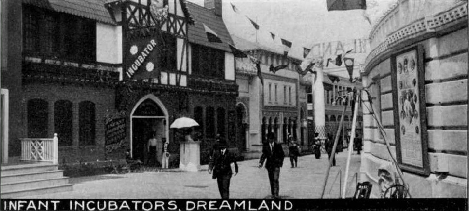 A post card of the Coney Island amusement park where the infant incubators were displayed shows several people walking among the fairground buildings