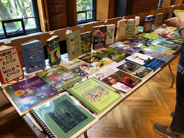 Photo showing a long table covered with books about outdoor learning at home and at school