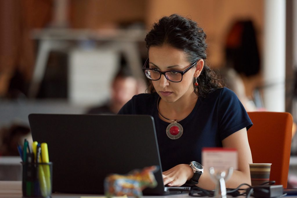 A woman works at a laptop