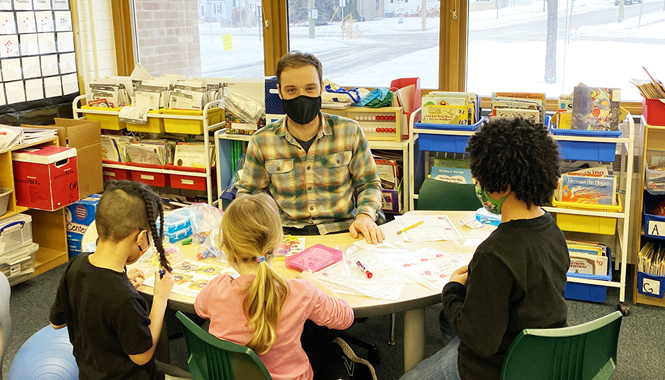 Chris Sanville teaches ESL students at a child-height round table.