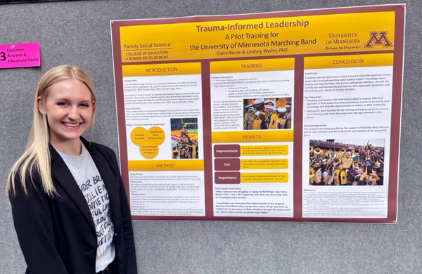 A student stands in front of her research poster.