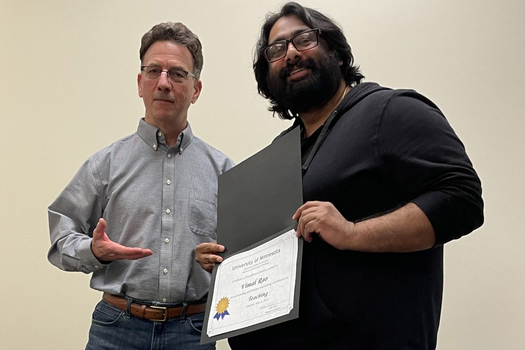 Vimal Rao (R) receives QME's Teaching Award from Associate Professor Robert delMas (L).