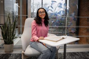 Graci W. in Campbell Hall sitting with an open textbook